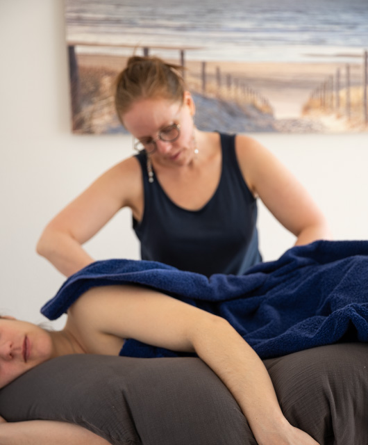 massage d'une femme enceinte couchée sur le côté